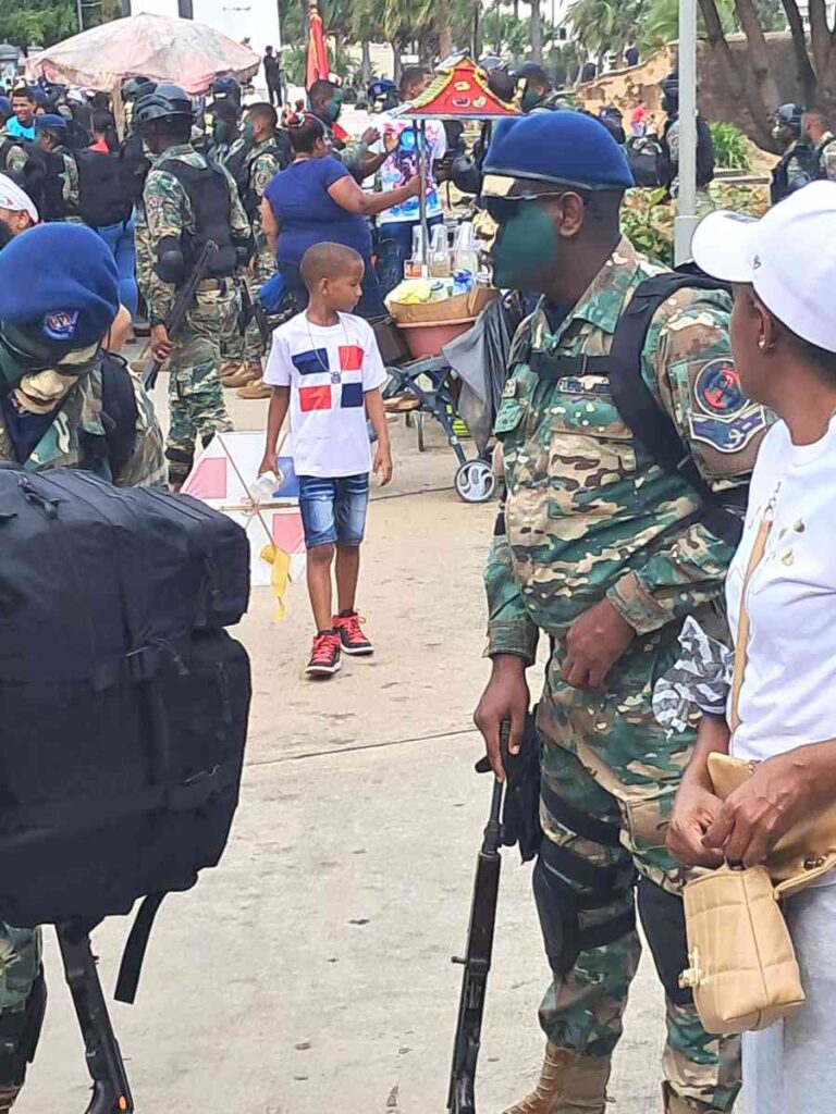 Niño con una camiseta de la bandera nacional. Antes del desfile, los militares se agrupan en el Malecón.